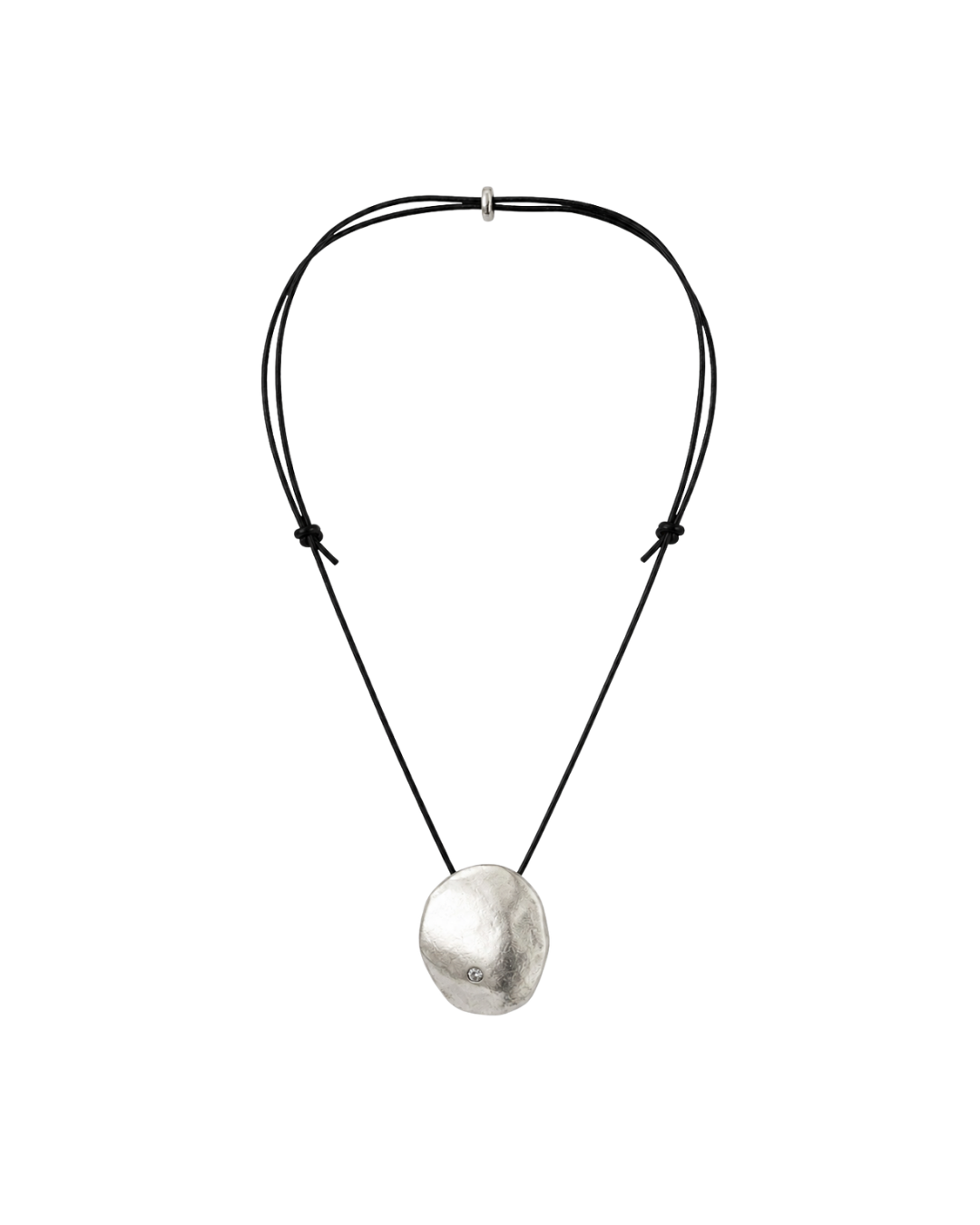 A minimalist necklace featuring a textured, irregularly shaped silver pendant suspended from a double-stranded black cord with adjustable knots and a silver toggle clasp.