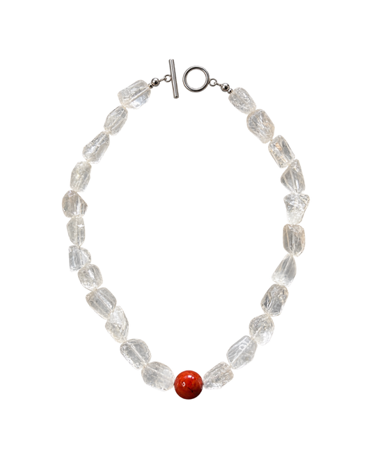 A beaded necklace made of clear faceted crystal-like beads with a single round red accent bead near the bottom center, finished with a silver toggle clasp, shown on a plain white background.