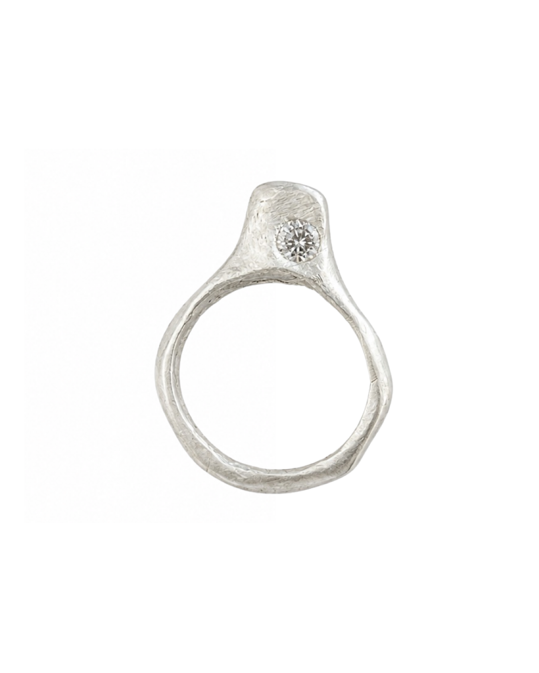 A textured sterling silver ring with a small round clear diamond set in off-center, shown against a plain white background.